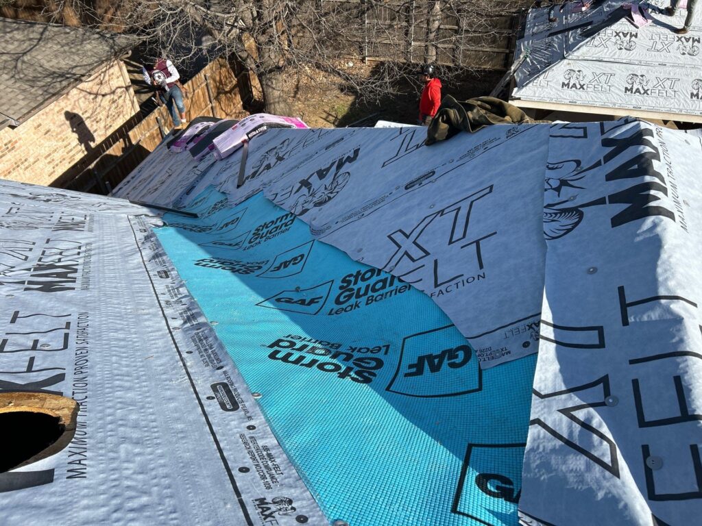 Roofers installing underlayment and leak barrier during a Dallas-Fort Worth residential roof replacement project.