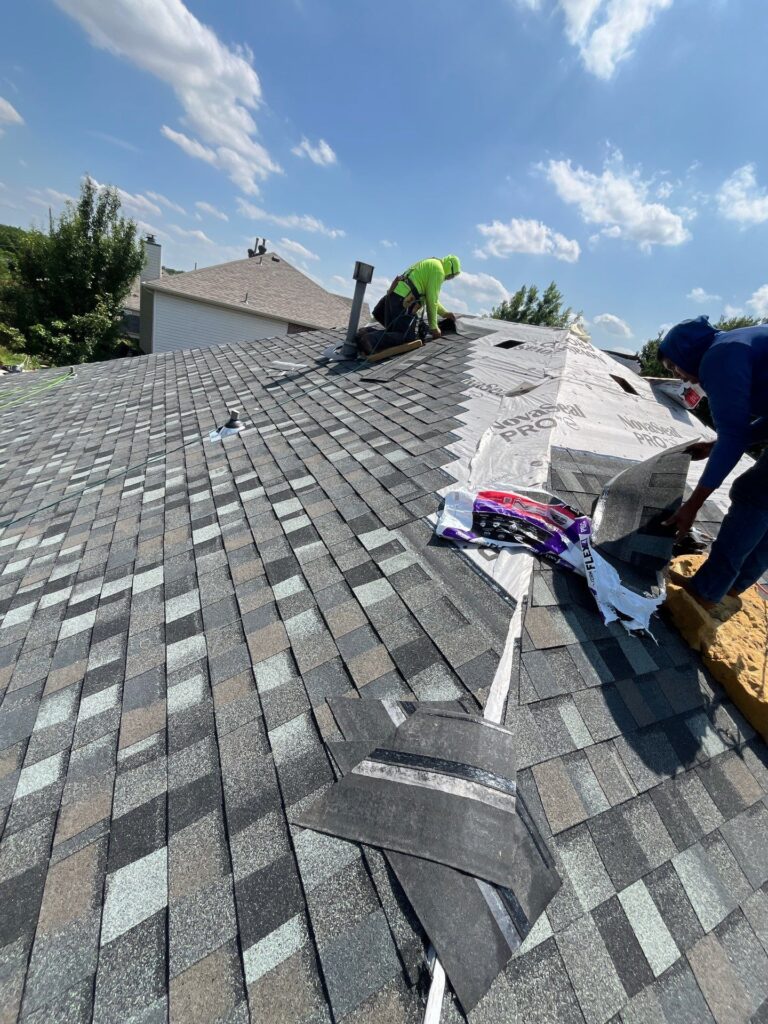 Roofers installing new architectural shingles on a residential roof in Dallas-Fort Worth.