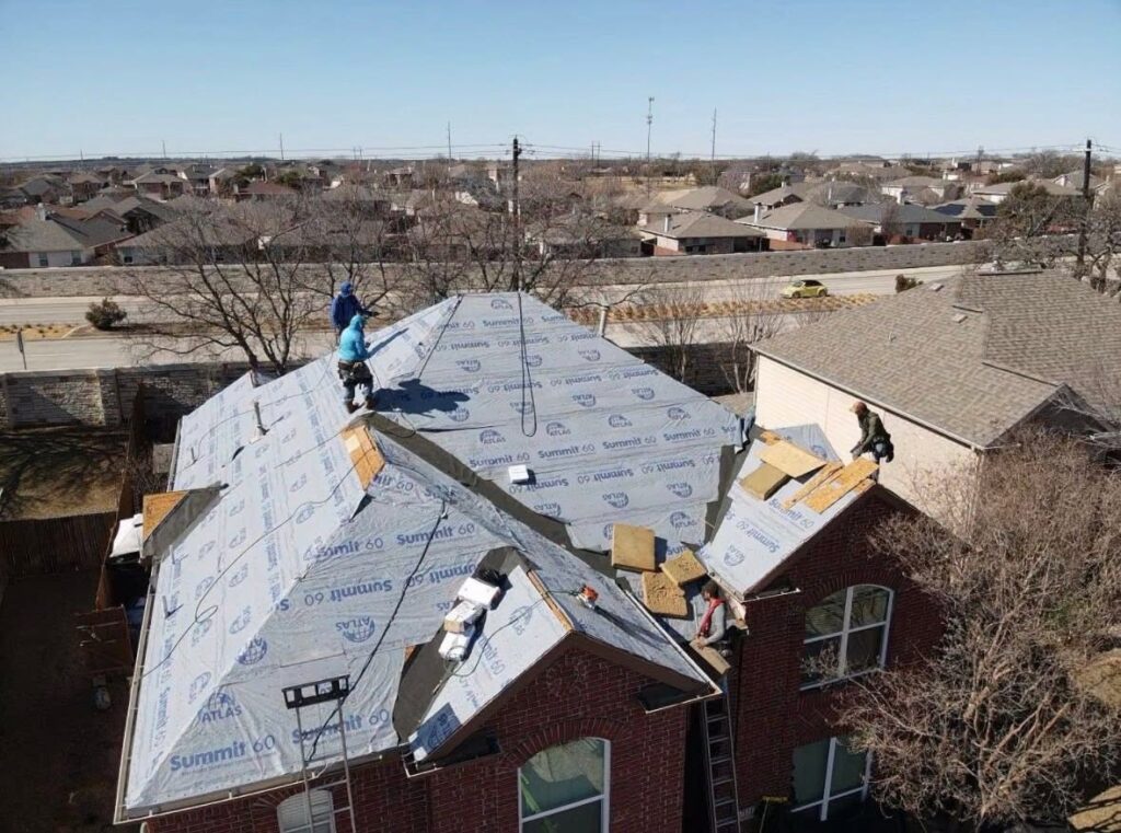 Roofers installing new underlayment during a complete residential roof replacement in Dallas-Fort Worth.