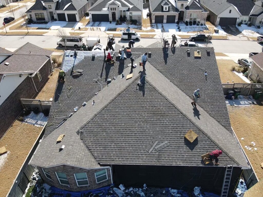 Roofers working on a complete roof replacement project in the Dallas-Fort Worth Metroplex.