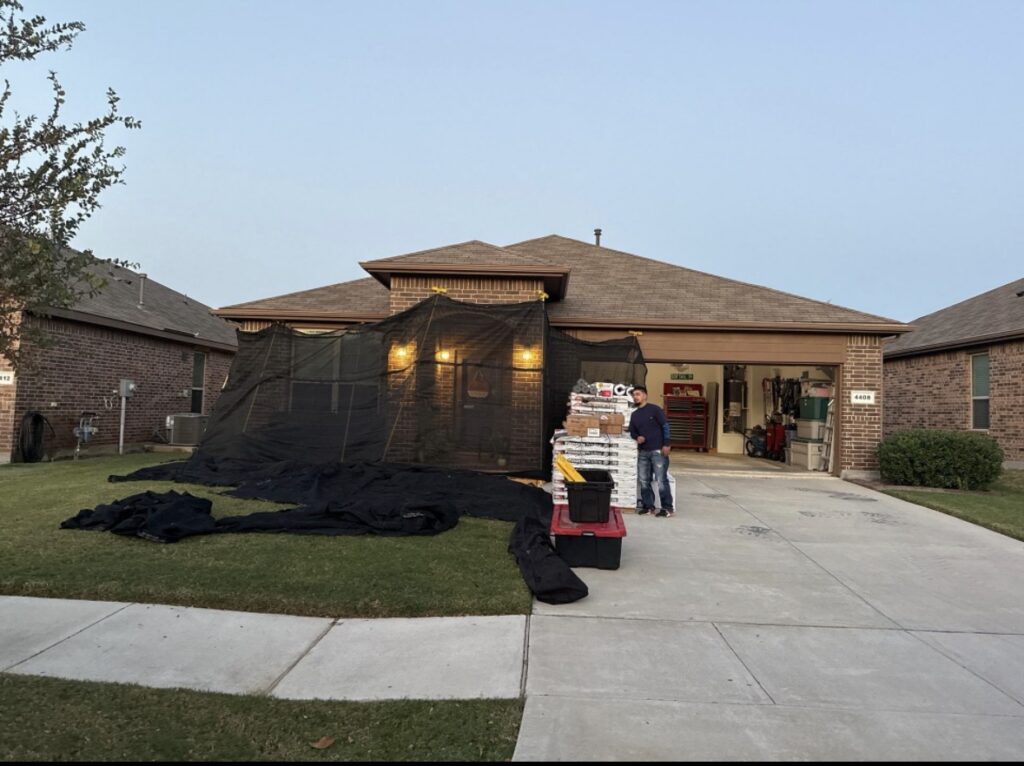 Residential home undergoing roof replacement with materials and protective netting in Dallas-Fort Worth.