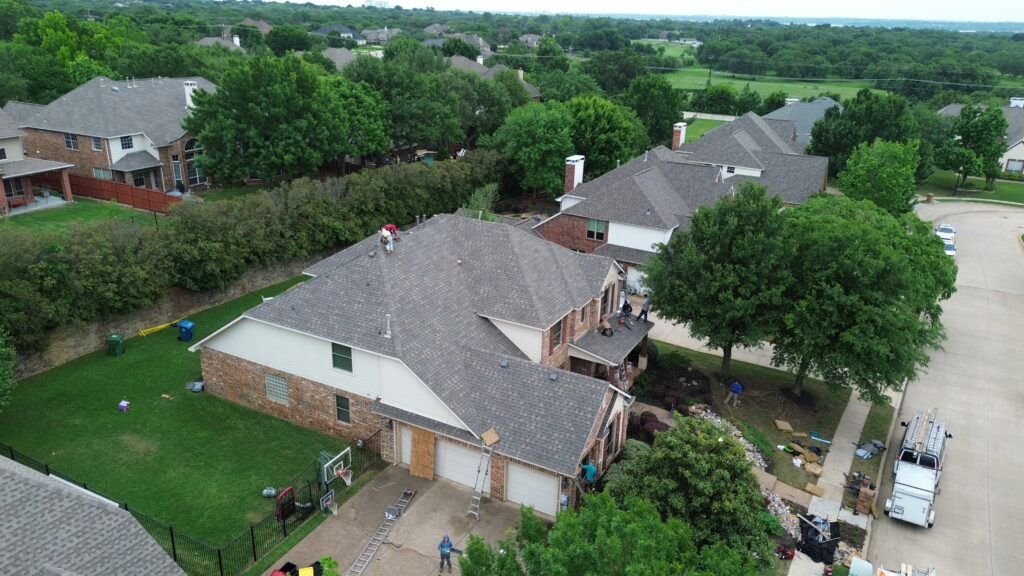 Aerial view of a completed roofing project in a North Texas neighborhood, showcasing Roofing Redefined's